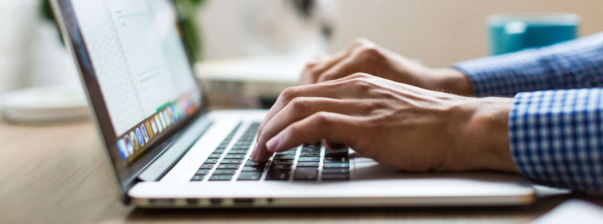 hands typing on laptop